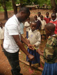 Field officer (Paul Nyindo) assist students in measuring poles for installing Kibuyu Chirizi