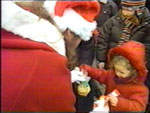 Gregor als Weihnachtsmann verkleidet verteilt Plätzchen, Mandarinen und Nüsse an die Kinder