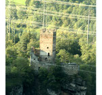 Strommasten und Stromleitungen vor einer Burgruine auf einem Felsen. Foto: Helga Karl