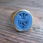 Handgefertigter Herren-Siegelring aus Gelbgold, gefasst mit einem blauen Lagenstein und kontrastreicher Wappen-Handgravur.