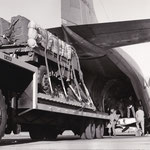 Embarquement d'un véhicule dans la soute d'un Transall. Les techniciens et ouvriers du CAP s'affairent.