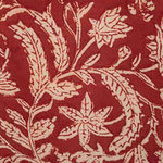 Fleurs et feuillage au milieu d'un champ de blés écru et rouge, l'ensemble imprimé sur un tissu rouge.