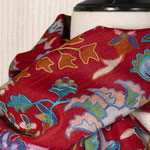 Étole en laine rouge foncé sur laquelle sont imprimés de nombreux motifs floraux.