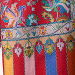 Pan de l'étole en laine présentant des bandes de couleurs ornées de fleurs imprimées. 