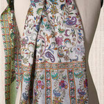 Étole en laine et soie, avec des fleurs multicolores imprimées sur un fond gris léger.