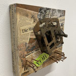 "Wer hat an der Uhr gedreht?" | MDF-Block, Uhrwerk, Zeitung, Nägel | 15 x 15 cm | 130 €