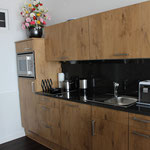Küchenzeile mit Cerankochfeld, Kaffeepadmaschine, Wasserkocher und Toaster