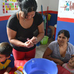 Madres de familia aprendiendo a lavar las manos de manera correcta