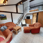 Studio Wohnzimmer mit Couch, Aufgang obere Etage mit Schlafzimmer