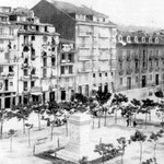 1869 Plaza Velarde desde el suroeste. En primer plano, el pedestal del monumento a Pedro Velarde, que habría de esperar más de diez años a la estatua; al fondo, La Ribera, con la Aduana a la derecha
