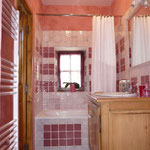 La salle de bains avec carrelages fait main, baignoire, wc. 