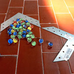"Piccola storia del mondo", 2024, glass marbles, galvanized metal, slope, 1 x30 x20 cm 