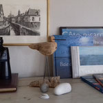 Étagère avec jumelles, oiseau en bois flotté, galets et livres sur la baie de Somme, intérieur du Bois Jaune