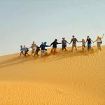 Voyageurs sur une dune de sable