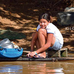 Girl washing dishes in the river 