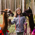 Mädchen mit 2 Alpakas posieren für ein Foto