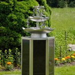 Edelstahlbrunnen -  Gartenbrunnen aus Edelstahl mit Efeuranken auf Granitsäule (© Raven Metall Design)