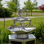 Edelstahlbrunnen -  Gartenbrunnen aus Edelstahl mit Efeuranken auf Granitsäule (© Raven Metall Design)