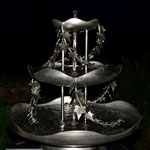 Edelstahlbrunnen -  Gartenbrunnen aus Edelstahl mit Efeuranken auf Granitsäule (© Raven Metall Design)