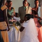 Feier - Braut und Bräutigam müssen jeweils den Schwiegereltern einen Kuchen überreichen - Die Braut kniet dabei