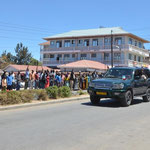 Nyerere Day in Tansania - Ein hoher Politiker rast an den auf den Presidenten wartenden Menschen vorbei