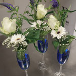 Blumenarrangement in Sektkelchen
