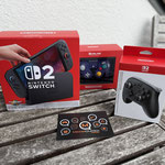 Das Bild zu Männerquatsch Podcast Folge 191 zeigt die "Nintendo Switch 2" inkl. Zubehör wie dem "Switch 2 Pro Controller" und dem "Gamecube Controller für Switch 2". 