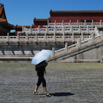 Une chinoise et son ombrelle traversant la cour impériale.