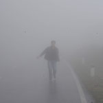 Mann im Nebel: Ein Mann läuft durch dichten Nebel auf einer Landstraße in Moc Chau.