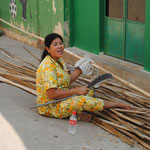 La nounou coupe du bambou pour faire le sol du poulailler