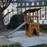 Rutschenturm mit Pultdach in Kita. Mit Klettervorhang und Spieltresen unter der Rutsche.