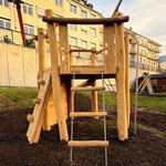 Spielturm mit steiler Rampe und Wackelleiter. Aus Robinie auf Spielplatz.