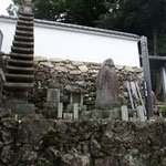 光秀、妻熙子（ひろこ）および明智一族の墓所（大津市坂本西教寺）（2020.9）　入口には坂本城の大手門を移築したと伝わる総門がある。また、供養米を寄進した自筆の書が残されている