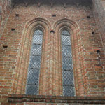 Die Lanzettfenster mit Gewände aus Viertelstab und Kehle, die regelmäßig angeordneten Löcher in der Außenwand dienten einst als Gerüstauflage