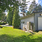 Autotalli/huoltorakennuksen sivulla vesi-ilmalämpöpumpun tekniikkaa