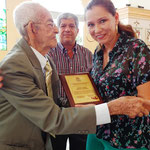 Presidenta del Patronato municipal de Bolívar (Manabí, Ecuador), Sandra González, entrega placa inscrita en honor a don José Manuel Sabando Navarrete.