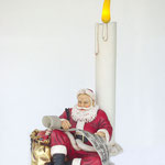 figura papá noel sentado junto a vela