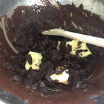 Schokolade auf dem Wasserbad schmelzen und die Butterstücke beigeben