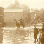 Flooding on the Warwick Road between the Green and Dudley Park Road, c. 1905. The Westley Brook flows under here, and has proved troublesome until sewer works at Station Road in the 1990s were undertaken. The cottages on the left are by the old New Inn.