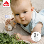 Baby spielt mit Fehn Mini-Rassel Teddy auf Krabbeldecke