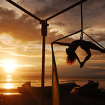 Astrid Roenig tanzt auf Aerial Silks im Sonnenuntergang am Meer