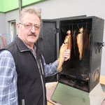 Senior Herbert bei seinem Räucherschrank - heimische Forellen goldbraun geräuchert