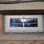 Fenêtre garage PVC extérieur gauche avec finition silicone blanc.