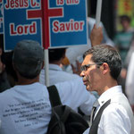 Hardcore-Christen demonstrieren lautstark vor der Filiale von Scientology, während deren Anhänger Gutscheine für einen gratis Persönlichkeitstest verteilen.