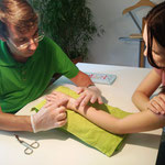 Therapeut untersucht vernarbtes Handgelenk einer Patientin