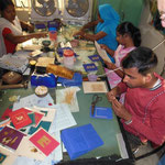 A group of young disabled people decorating cards with rice straw. This activity provides them with occupation, community and income.