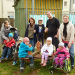 Einige Eltern und Kinder mit Frau Fischer an der alte maroden Feder-Wippe