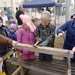 Wieder zurück auf dem Marktplatz wo zahlreiche Spiele angeboten wurden: Hier versuchen die Kleinen mit möglichst wenig Schlägen Nägel in einen Balken zu bringen