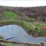 View over the mill pond and valley to wind turbines on the opposite ridge