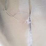 Finition en couture invisible de l'intérieur d'un gilet homme.